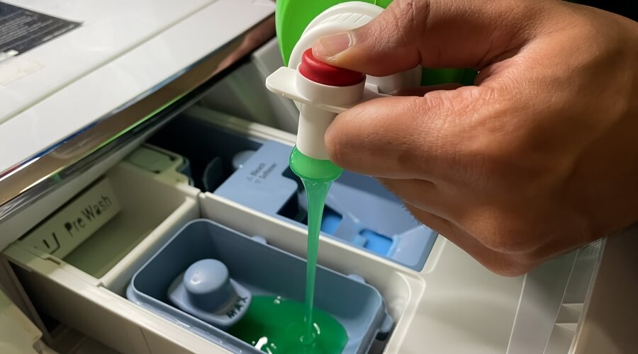 Pouring detergent into washing machine detergent drawer